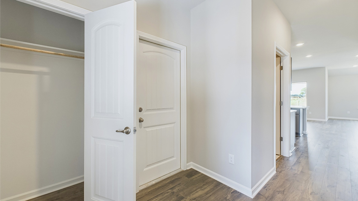 Hallway view towards spacious living room with access to dining and kitchen areas, and outside access at Hollis Heights