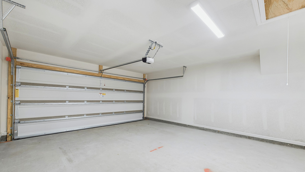 New build home with inside view of garage. Garage door, storage potential by D.R. Horton featuring one story connectivity