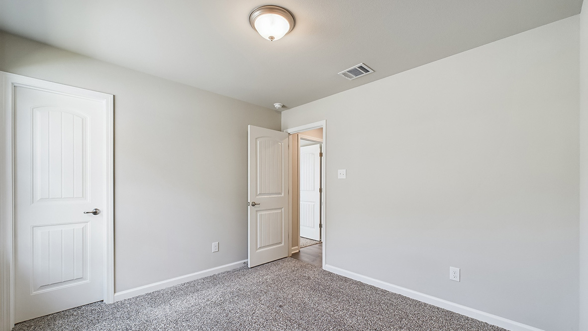 Bedroom with neutral walls, closet space, and natural lighting.