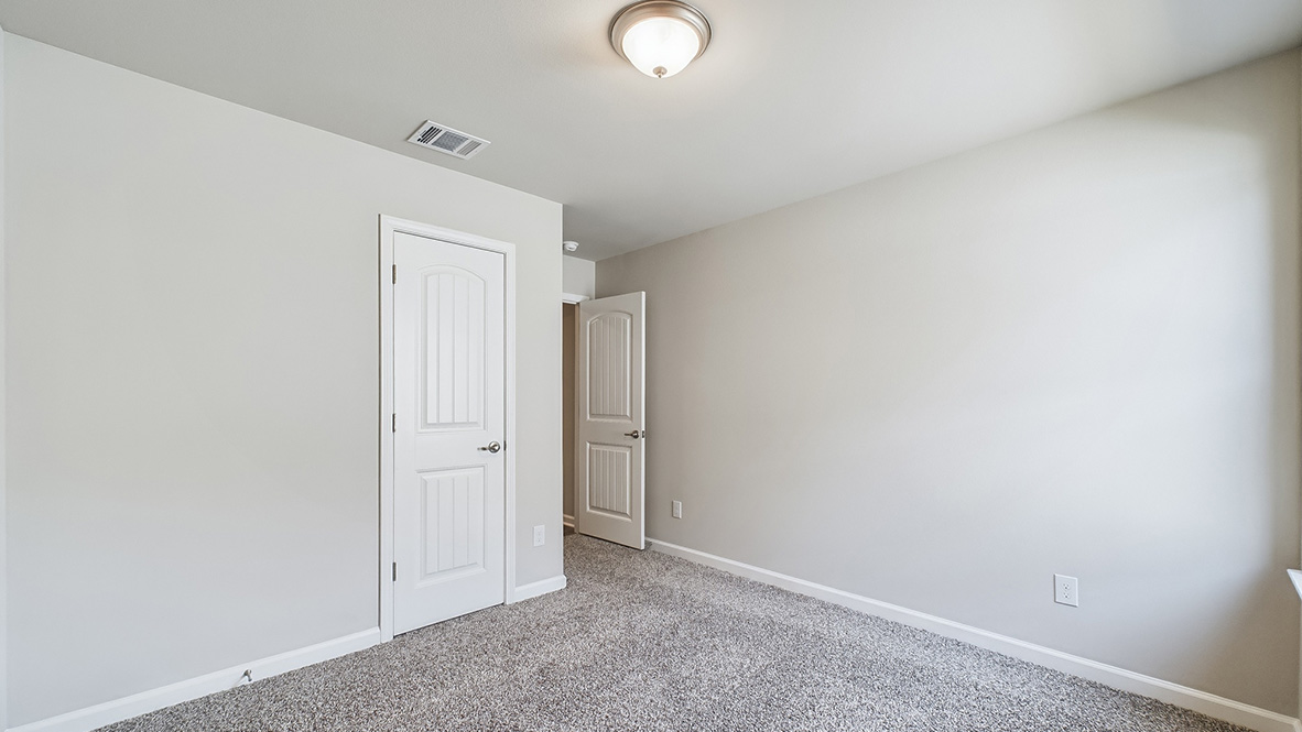 Bedroom with neutral walls, closet space, and natural lighting.