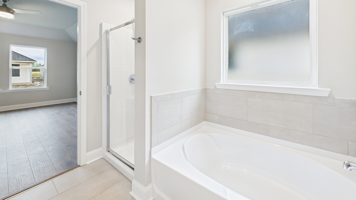 bathroom with dual vanity sinks, toilet, bath tub and a walk in shower