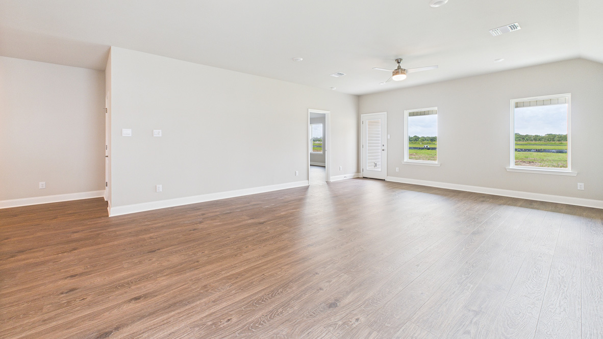 Living room looking into the back yard is near dining and kitchen areas in this new home features natural light, connectivity