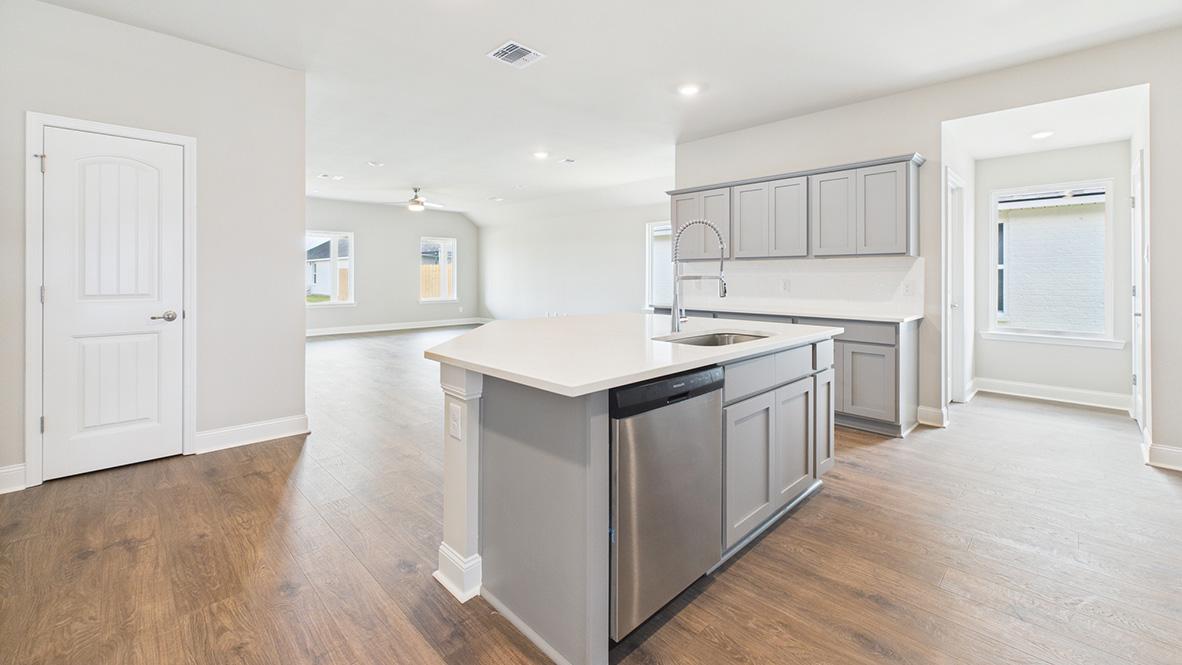 Central kitchen island anchors the home adding a dining option, full sink, pantry and storage, multi-prep zones