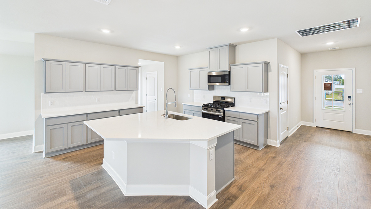 Kitchen island in D.R. Horton layout connects dining, main living areas, and outside with efficient flow and modern designs