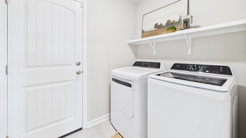 Utility room with dryer connection and shelf above