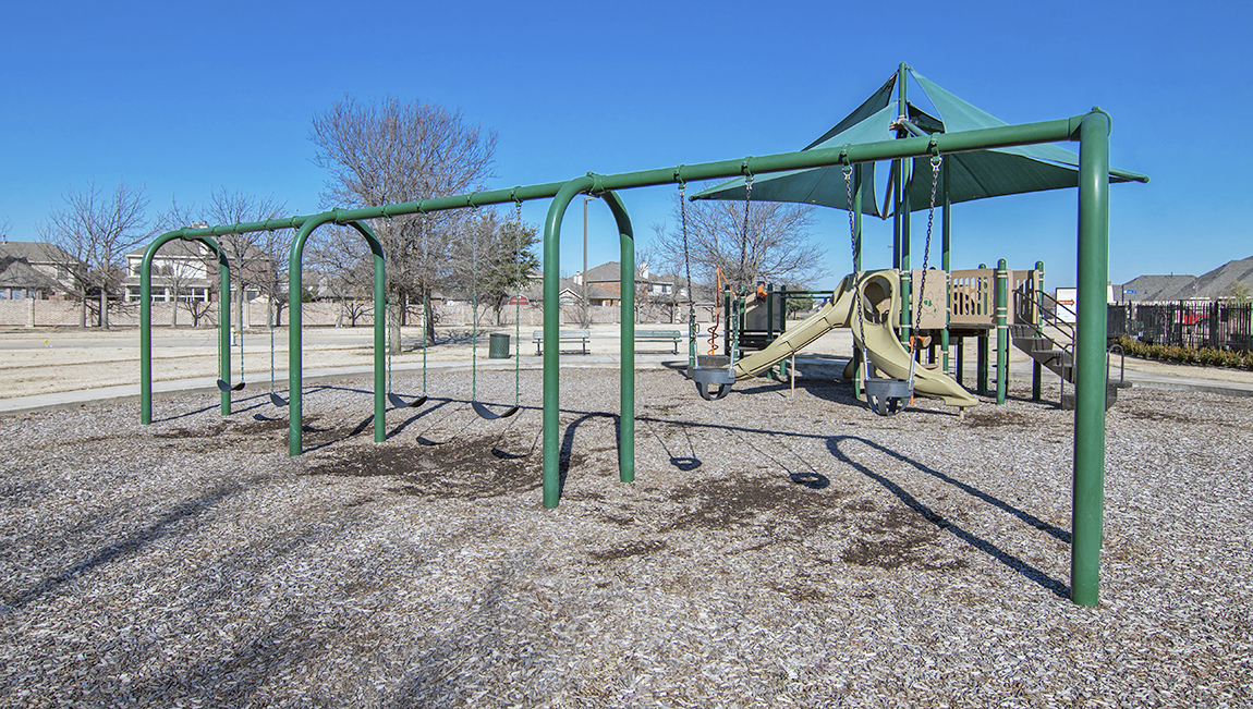Woodcreek playground with green swingset