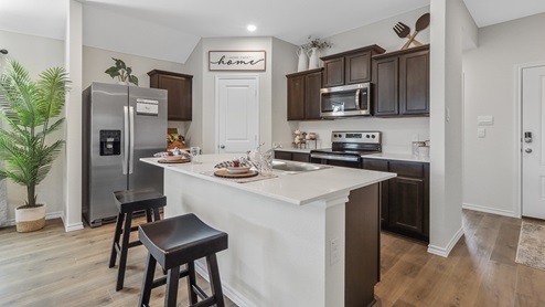 X40E Elgin floorplan kitchen area with island and stainsteel range gallery image-Leonard Crossing in Leonard, TX