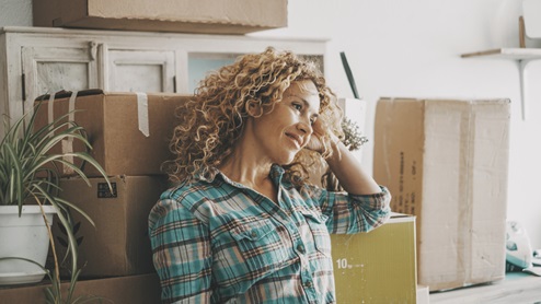 Women leading again shelf with moving boxes