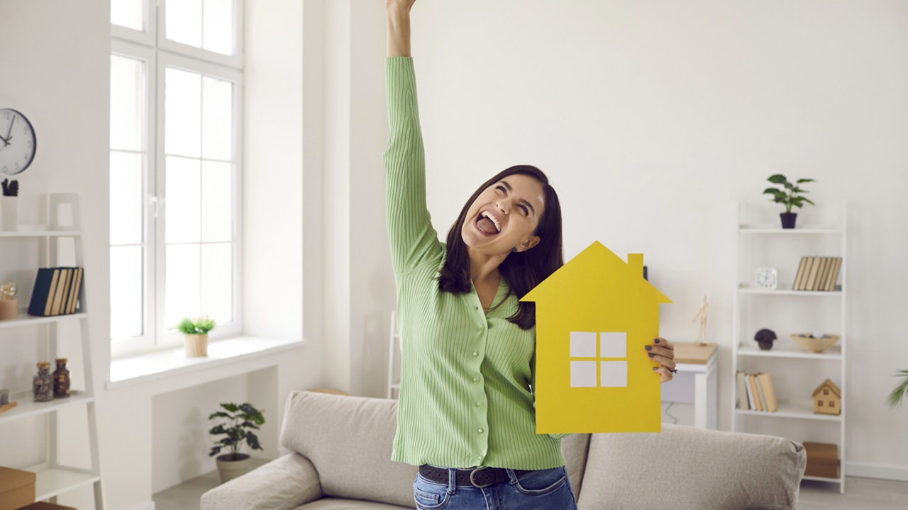 Women with arm up and holding a home cutout