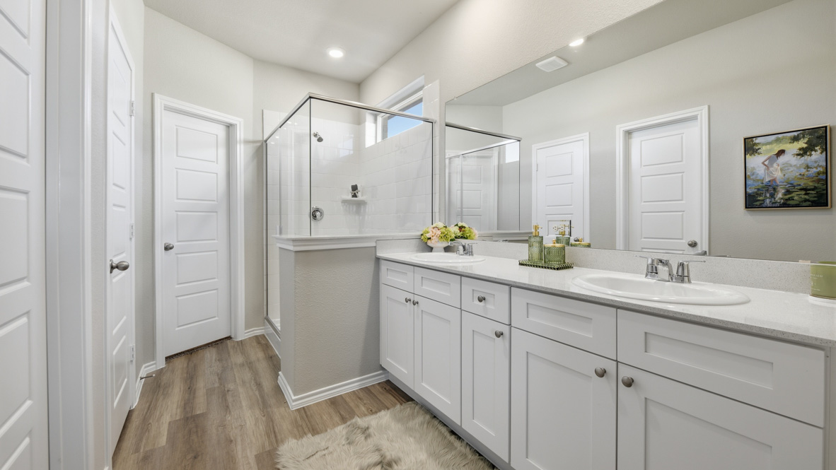 Spacious primary bathroom with ample counterspace and luxurious tiled shower