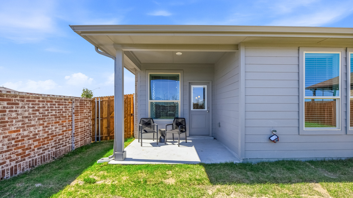 Covered back patio space overlooking spacious backyard