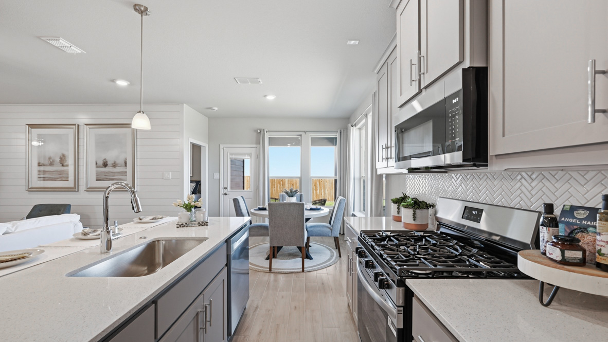 Kitchen with stainless steel appliances, tile backsplash, and luxurious countertops
