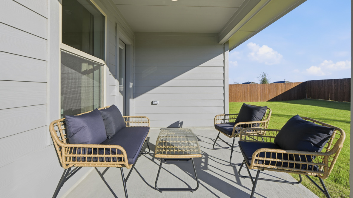 Covered back patio overlooking green backyard