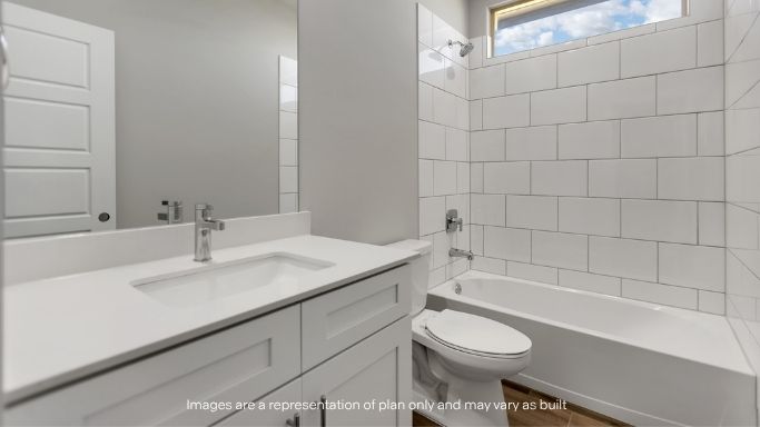 Full bath with tub/shower combo and modern design.