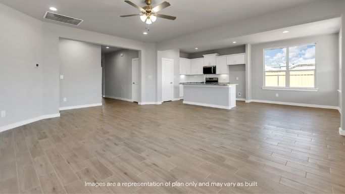 Open-concept living space with wide layout and wood-style flooring.