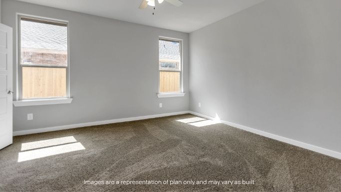 Primary bedroom with plush carpet floors and light allowing double windows
