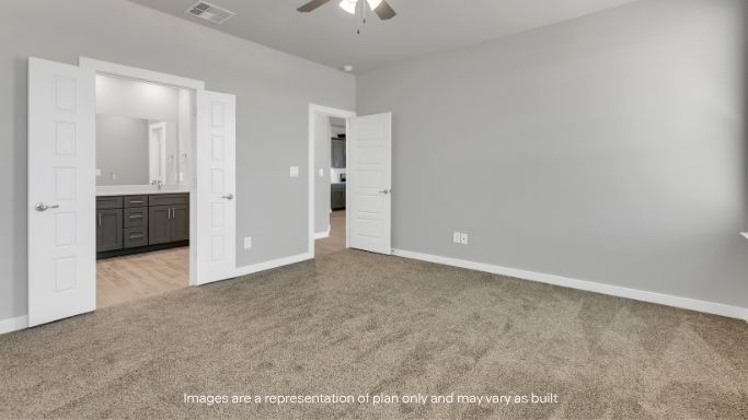 Primary bedroom with plush carpet and direct access to ensuite bath.