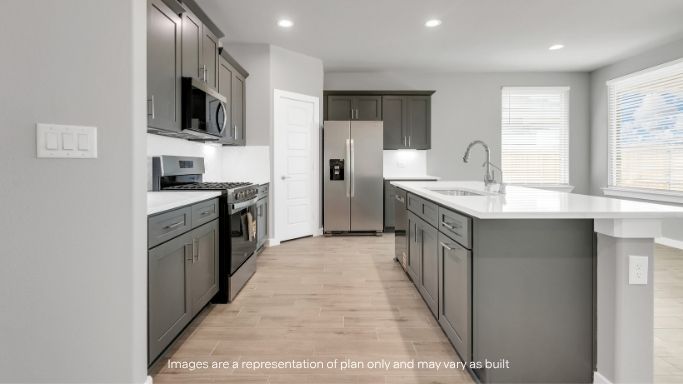 Modern kitchen with gray cabinetry, stainless steel appliances, and a large island.