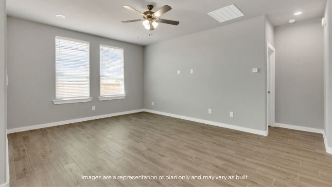 Spacious living room with ceiling fan and natural light.