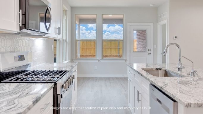 Open concept kitchen with stainless steel appliances, shaker style cabinets, and elevated finishes