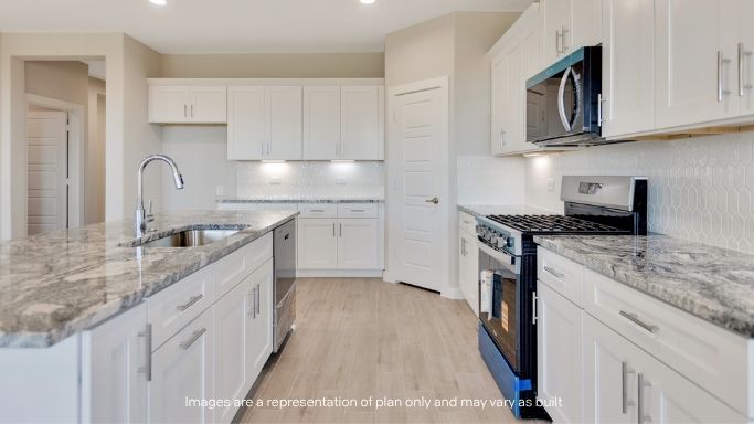 Open concept kitchen with stainless steel appliances, shaker style cabinets, and elevated finishes