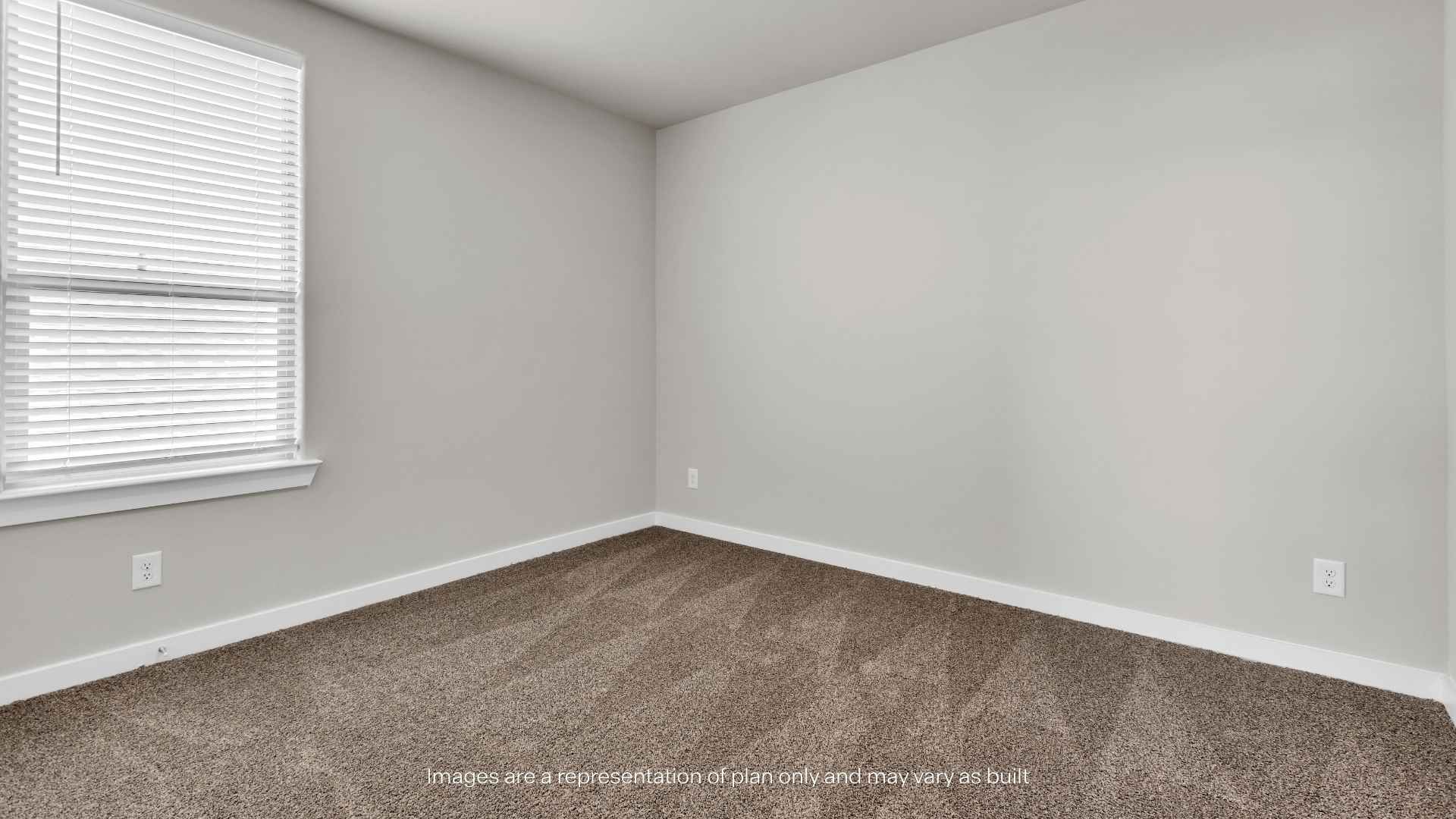 Bedroom with carpet flooring, neutral walls, and a window with blinds.
