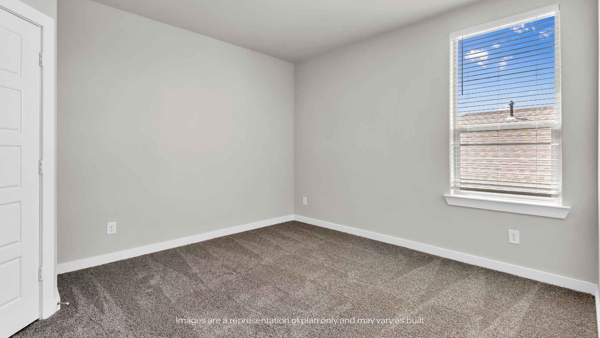 Bedroom with carpet flooring, neutral walls, and a large window with blinds.