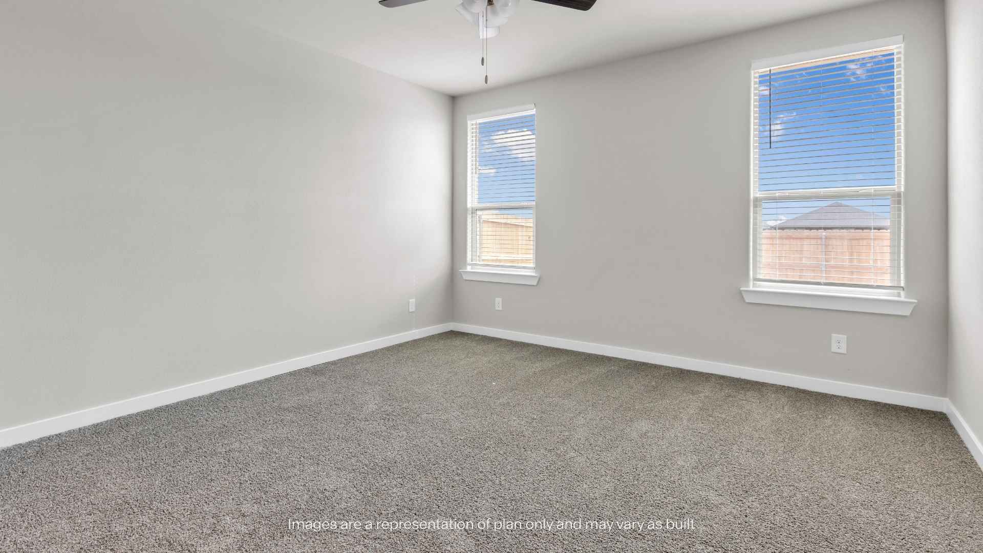 Bedroom with carpet flooring, ceiling fan, and two windows providing natural light.  Provide your feedback on BizChat