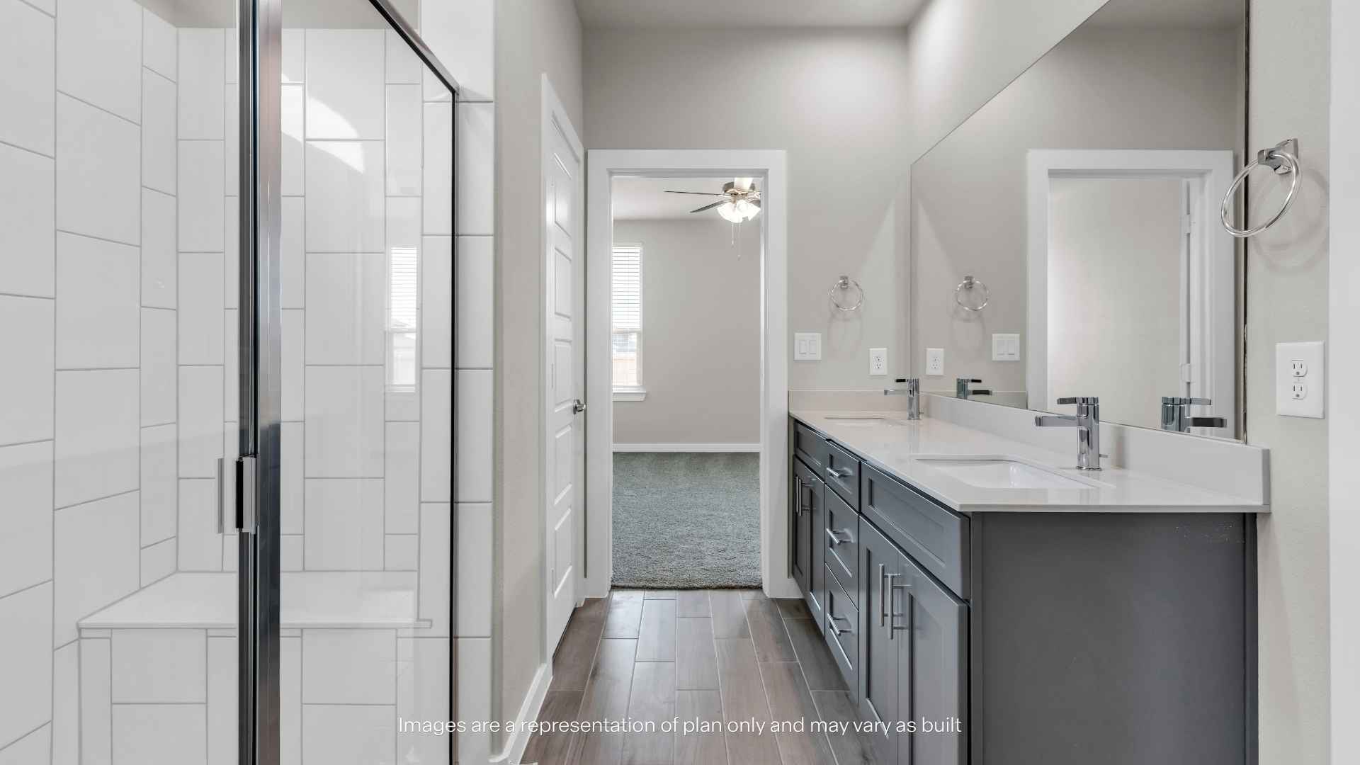Primary bathroom with dual-sink vanity, large mirror, and glass-enclosed shower.