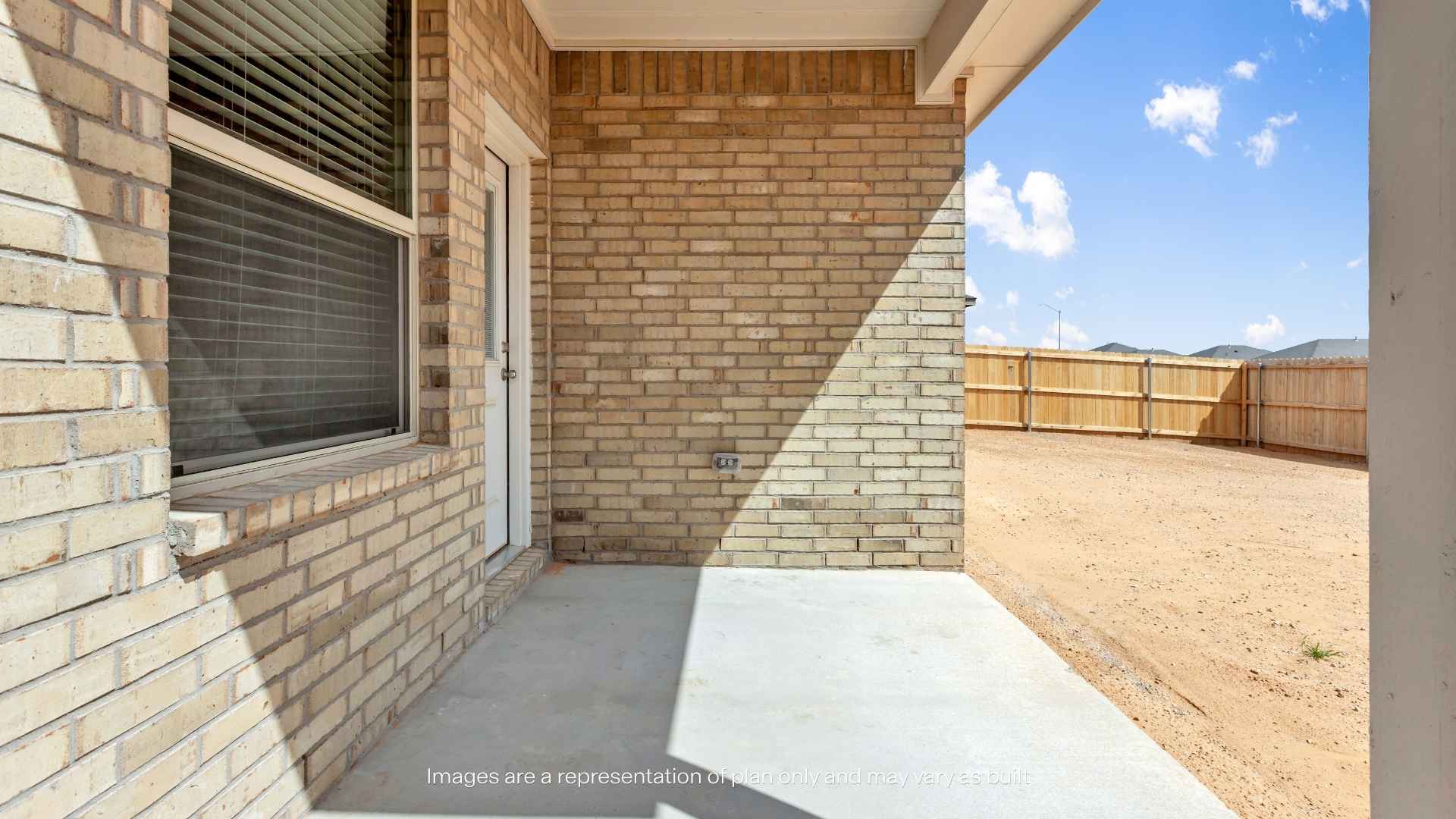 Covered patio with brick exterior, concrete slab, and fenced backyard.