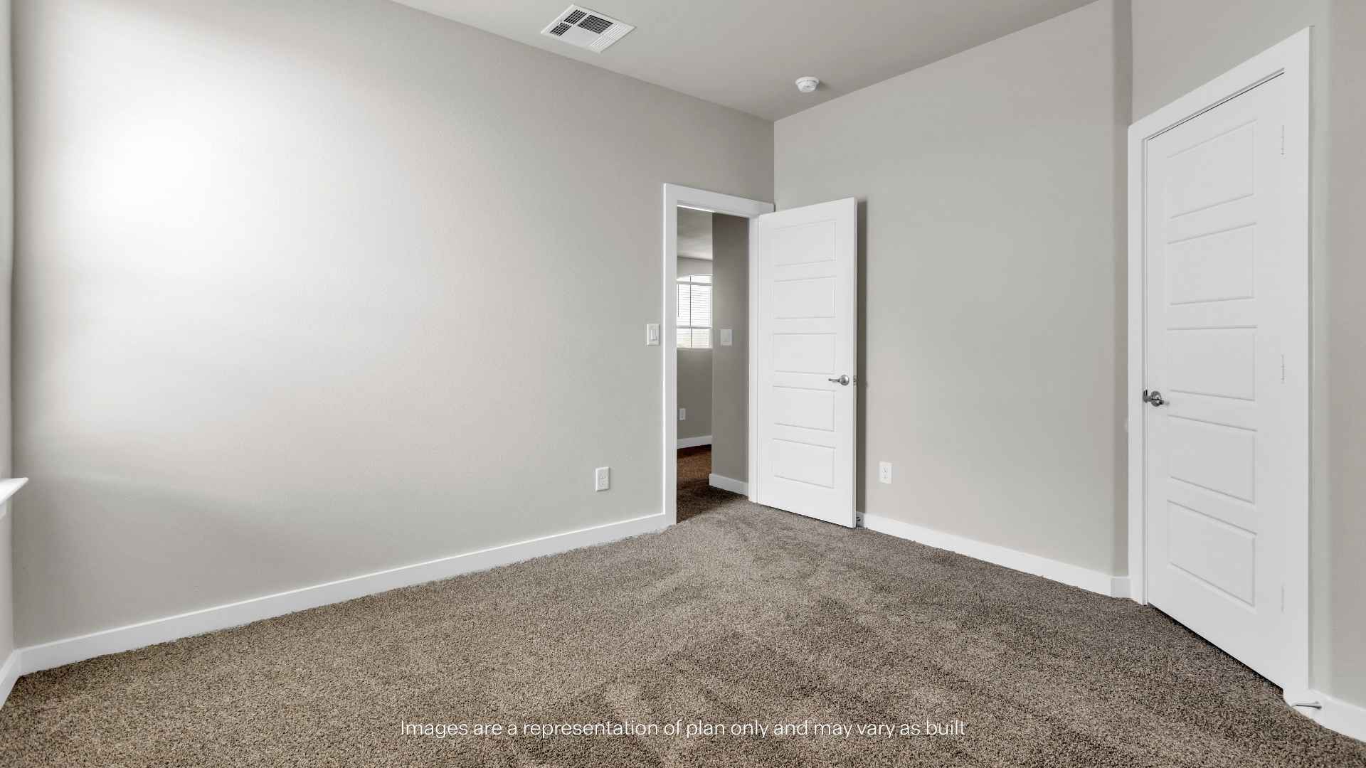 Bedroom with carpet flooring, neutral walls, and closet access.