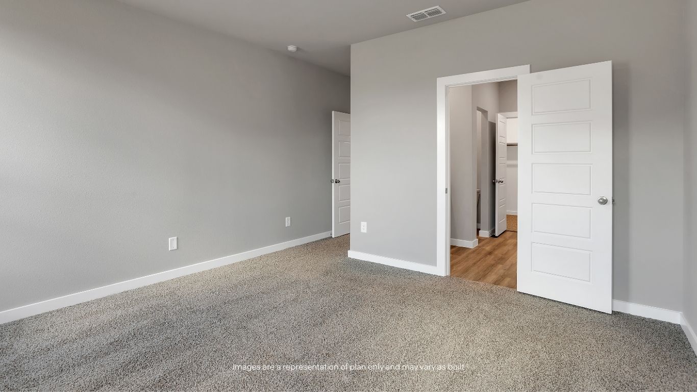 The spacious primary suite offers plush carpeting, natural light, and ample room to create your own private retreat.