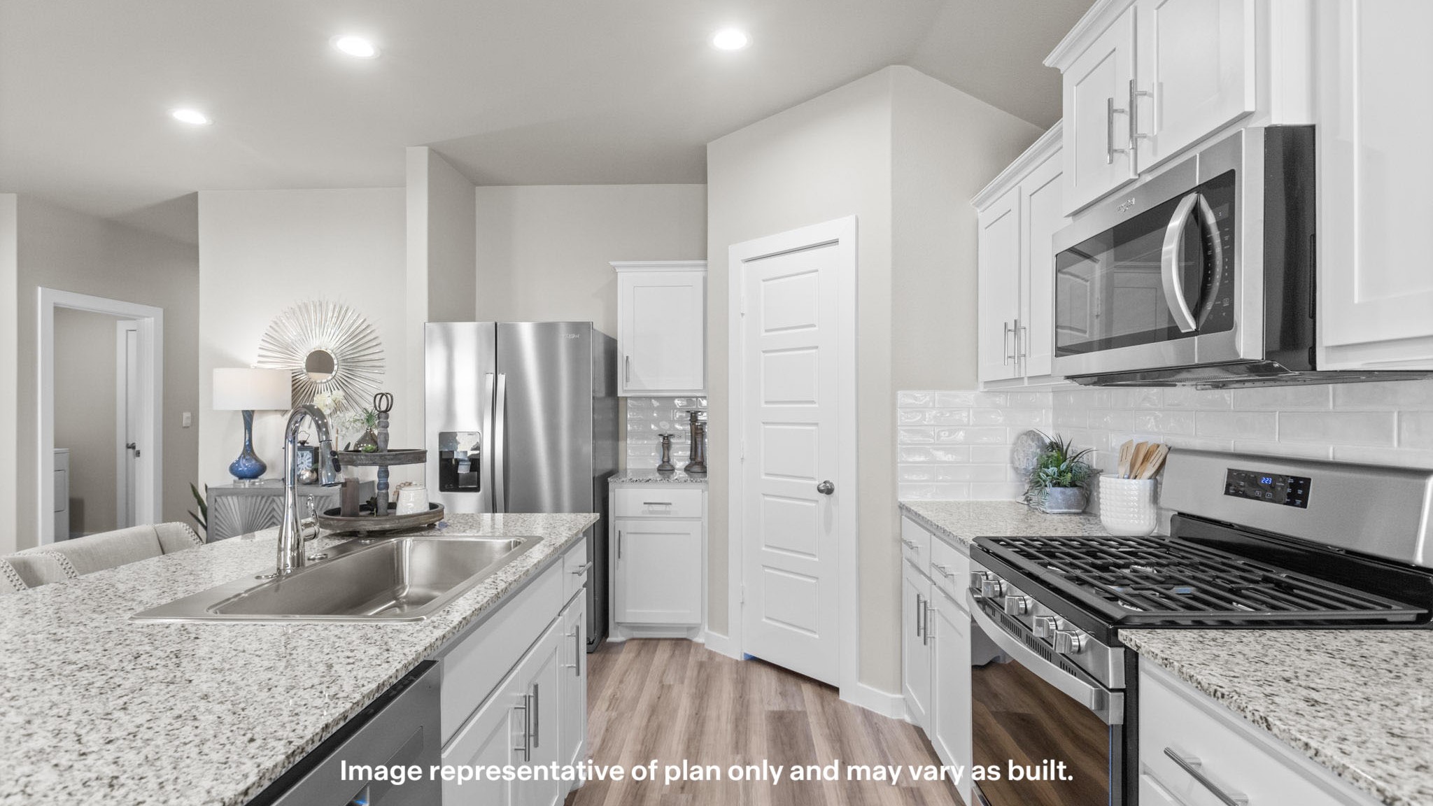 Open concept kitchen with stainless steel appliances, shaker style cabinets, and elevated finishes