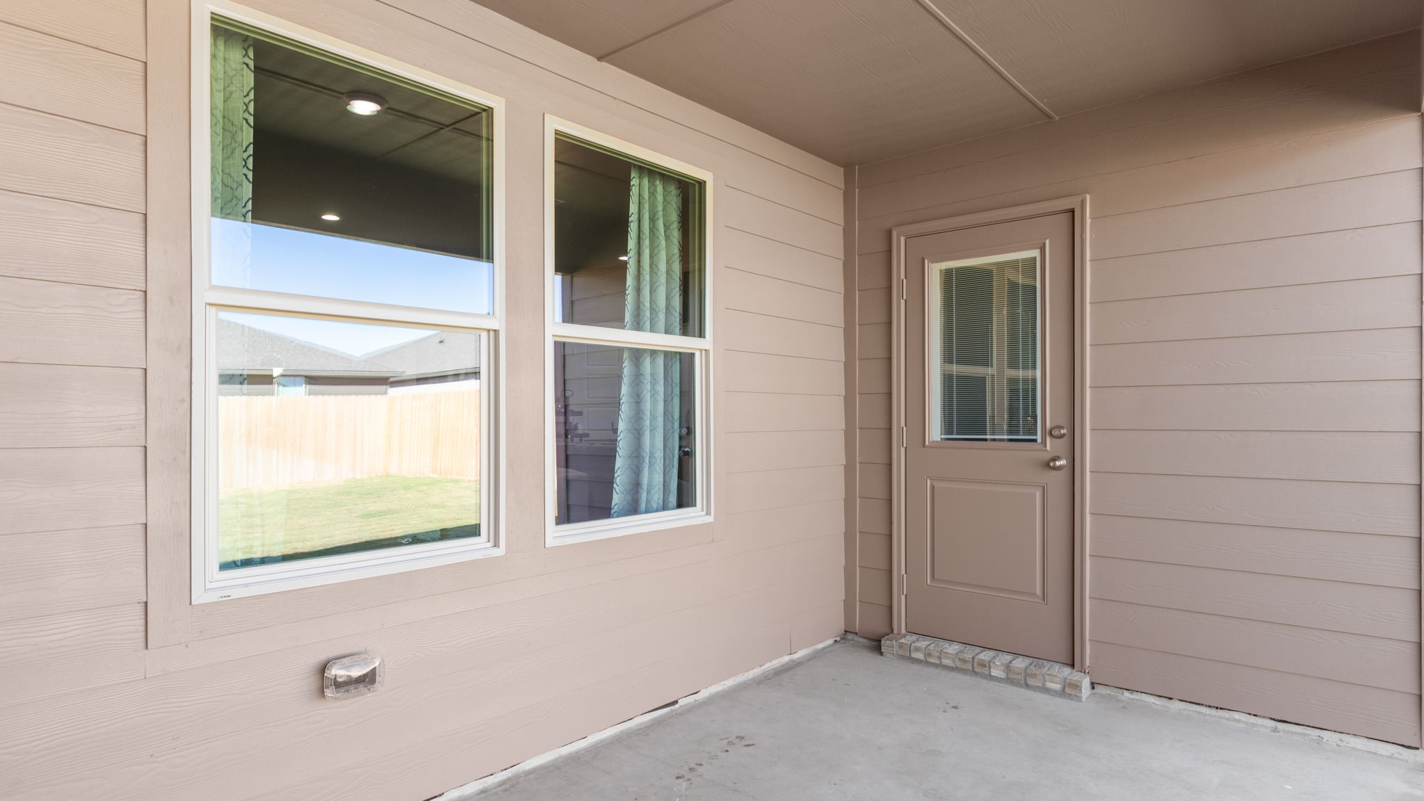 Covered back patio area overlooking spacious backyard