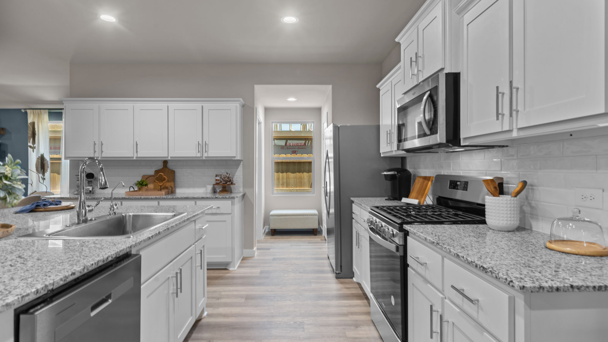 Open concept kitchen with stainless steel appliances, shaker style cabinets, and elevated finishes