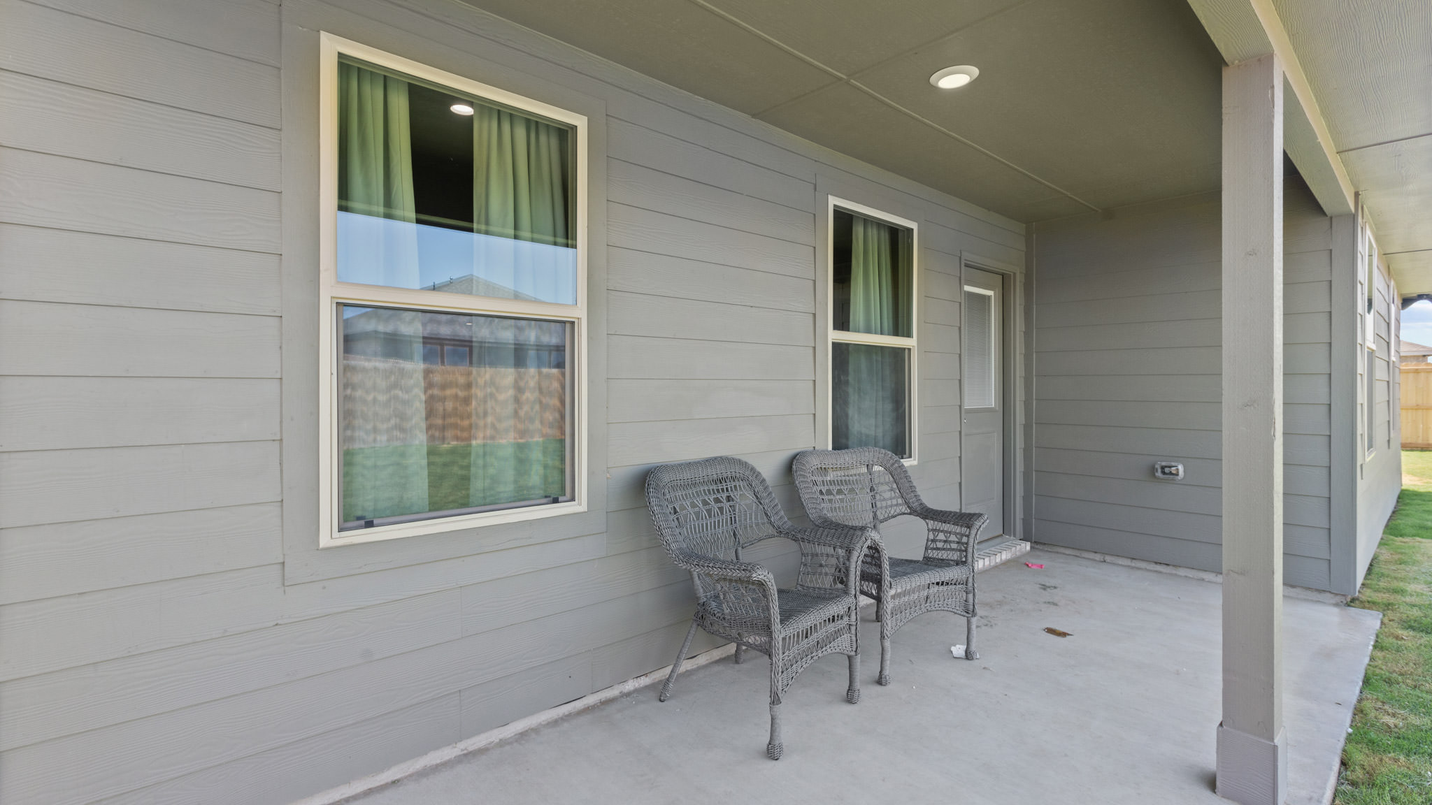 Covered back patio area overlooking spacious backyard