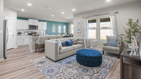 Open concept living and family room area neutrally decorated with blue accents