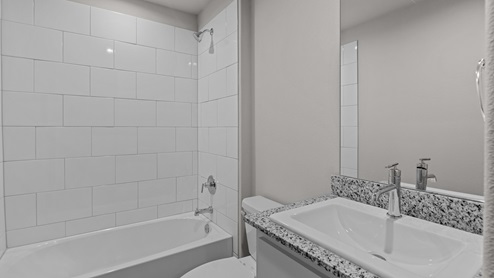 Guest bathroom with tile shower and vanity