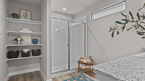 Primary bathroom with walk-in shower and built in storage shelving