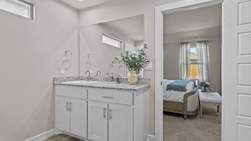 Primary bathroom area with marble vanity tops