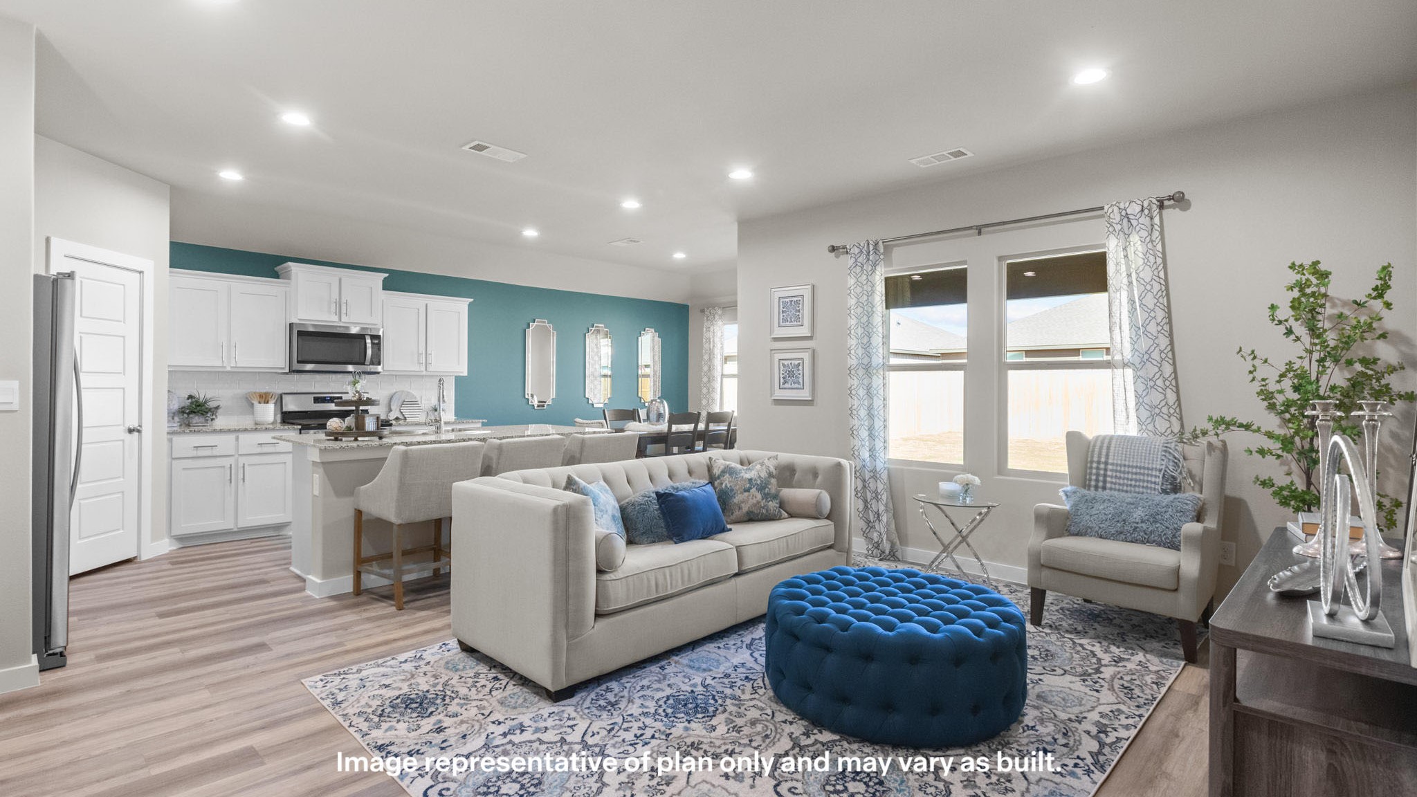 Open concept living and family room area neutrally decorated with blue accents