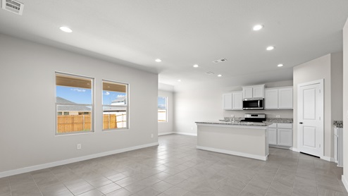 A pristine kitchen with white cabinets and tiled flooring, exuding cleanliness and elegance.