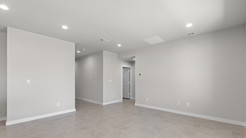 An empty room with white walls and gray flooring, creating a minimalist and neutral ambiance.