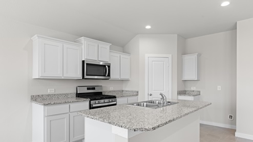 Modern kitchen with white cabinets and granite counter tops, creating a sleek and elegant design.