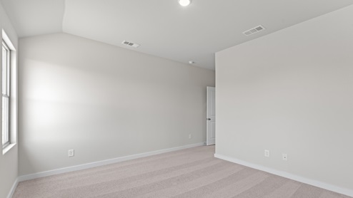 An empty room with white walls and gray flooring, creating a minimalist and neutral ambiance.