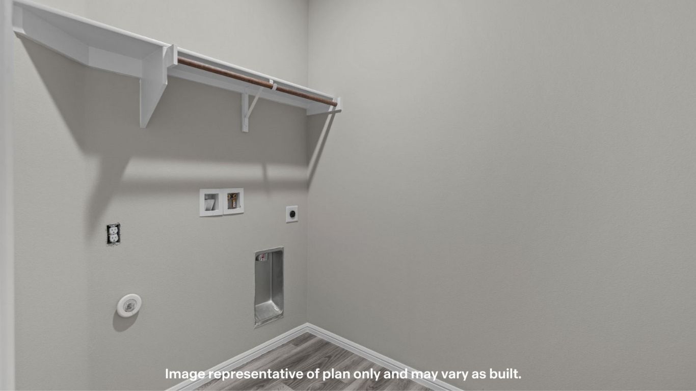 Functional laundry room with washer/dryer hookups, built-in shelving, and storage space.