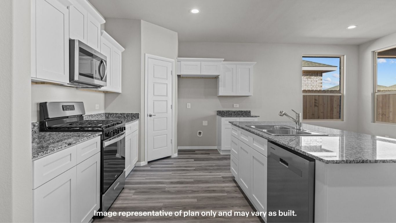 Bright kitchen with white cabinetry, stainless steel appliances, and granite countertops.
