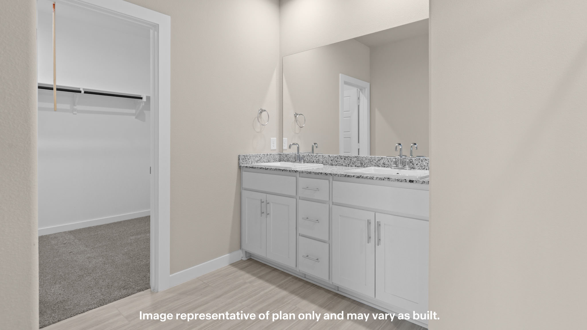 Dual vanities with granite countertops provide both style and convenience in the well-appointed primary bathroom.