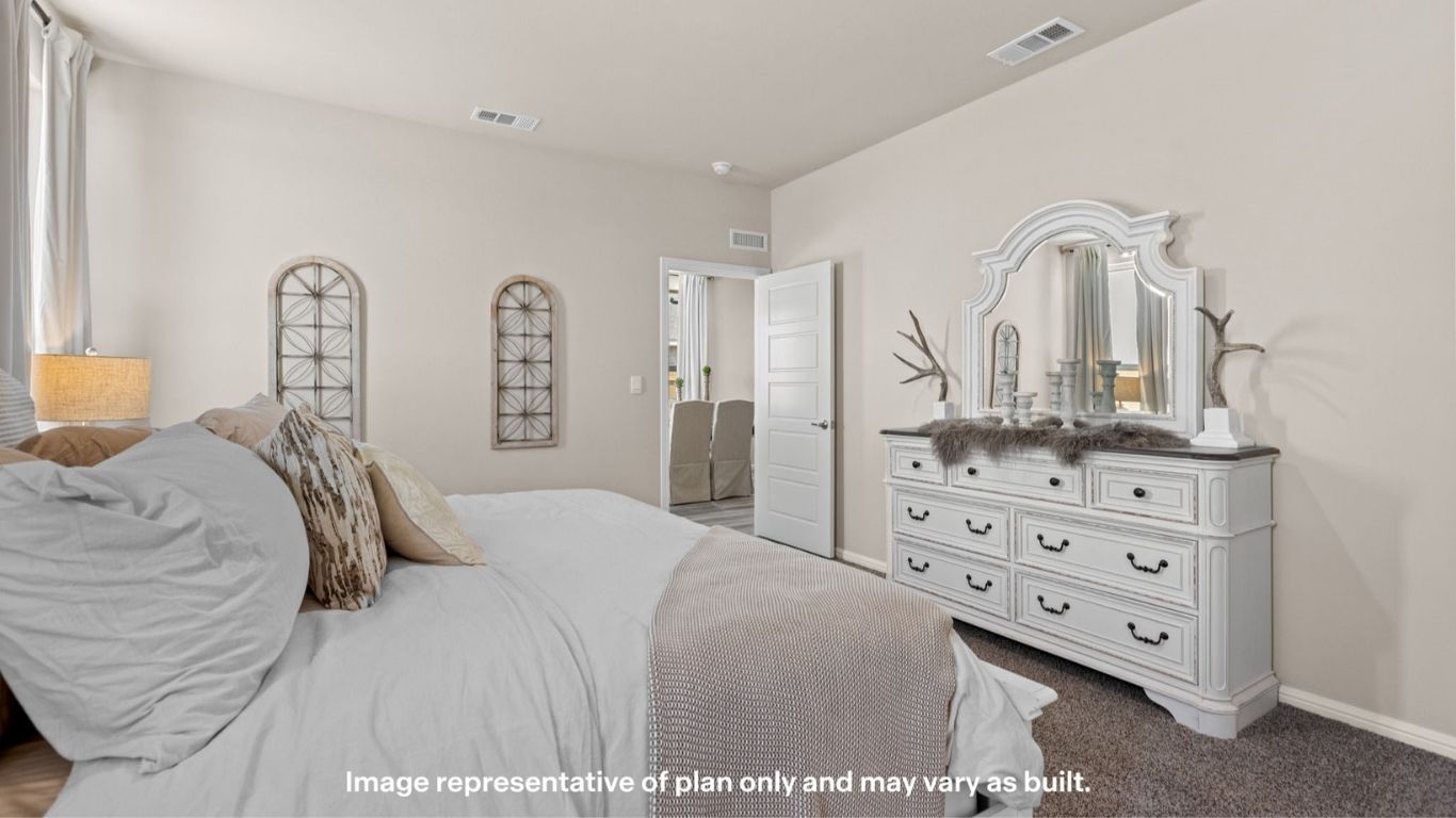 Primary bedroom with plush carpet and elegant décor.