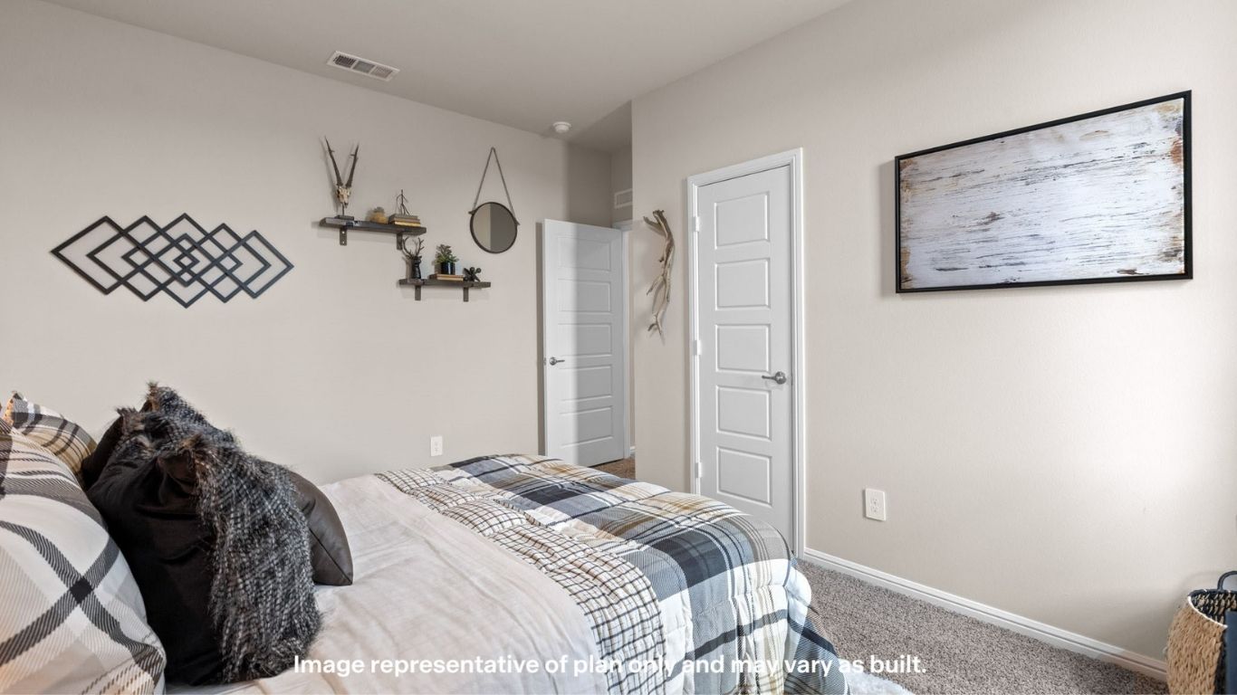 Alternate view of the primary bedroom showcasing wall décor and doorway access.